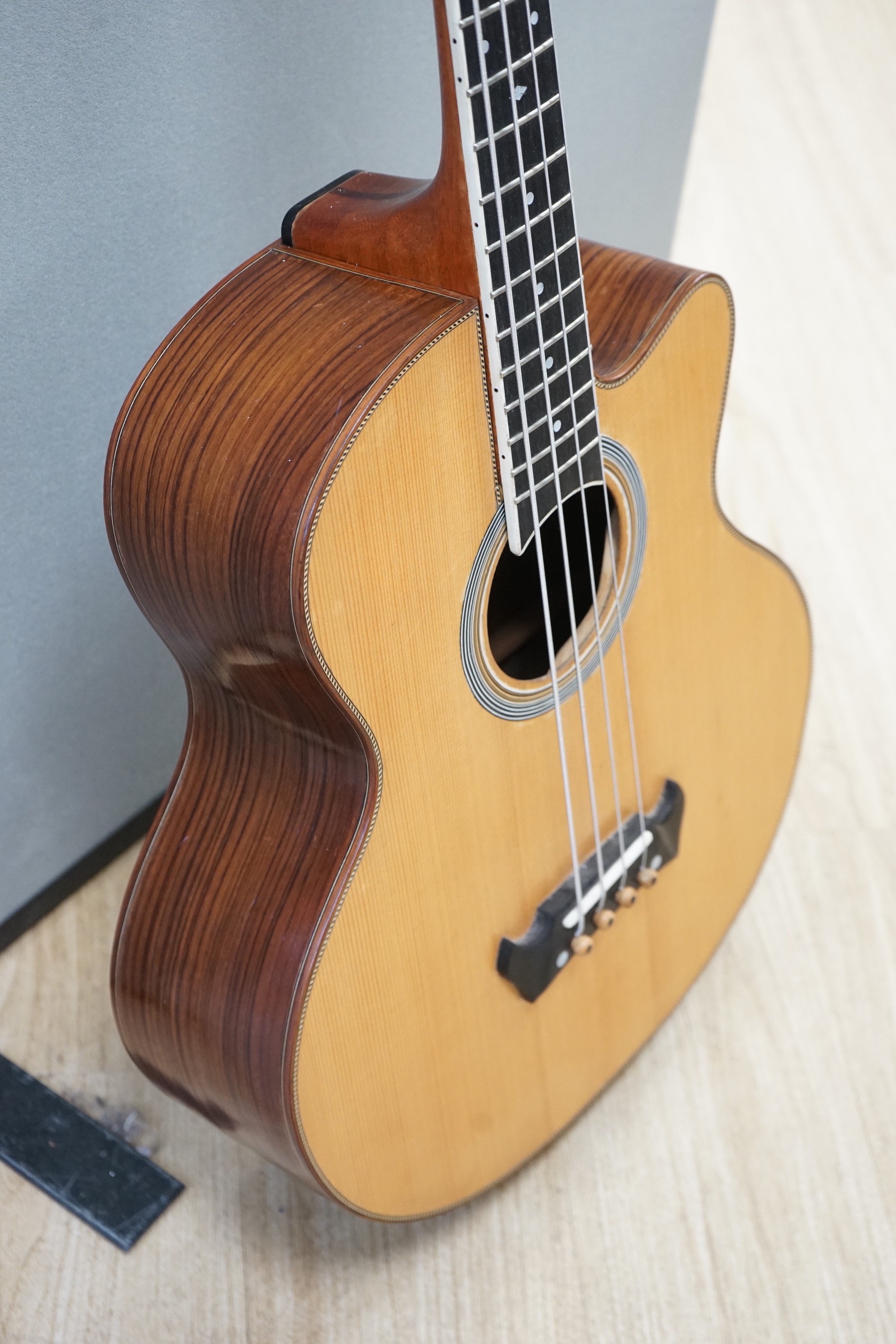 An Acoustic bass guitar, made by John Degay of Degay Guitars
